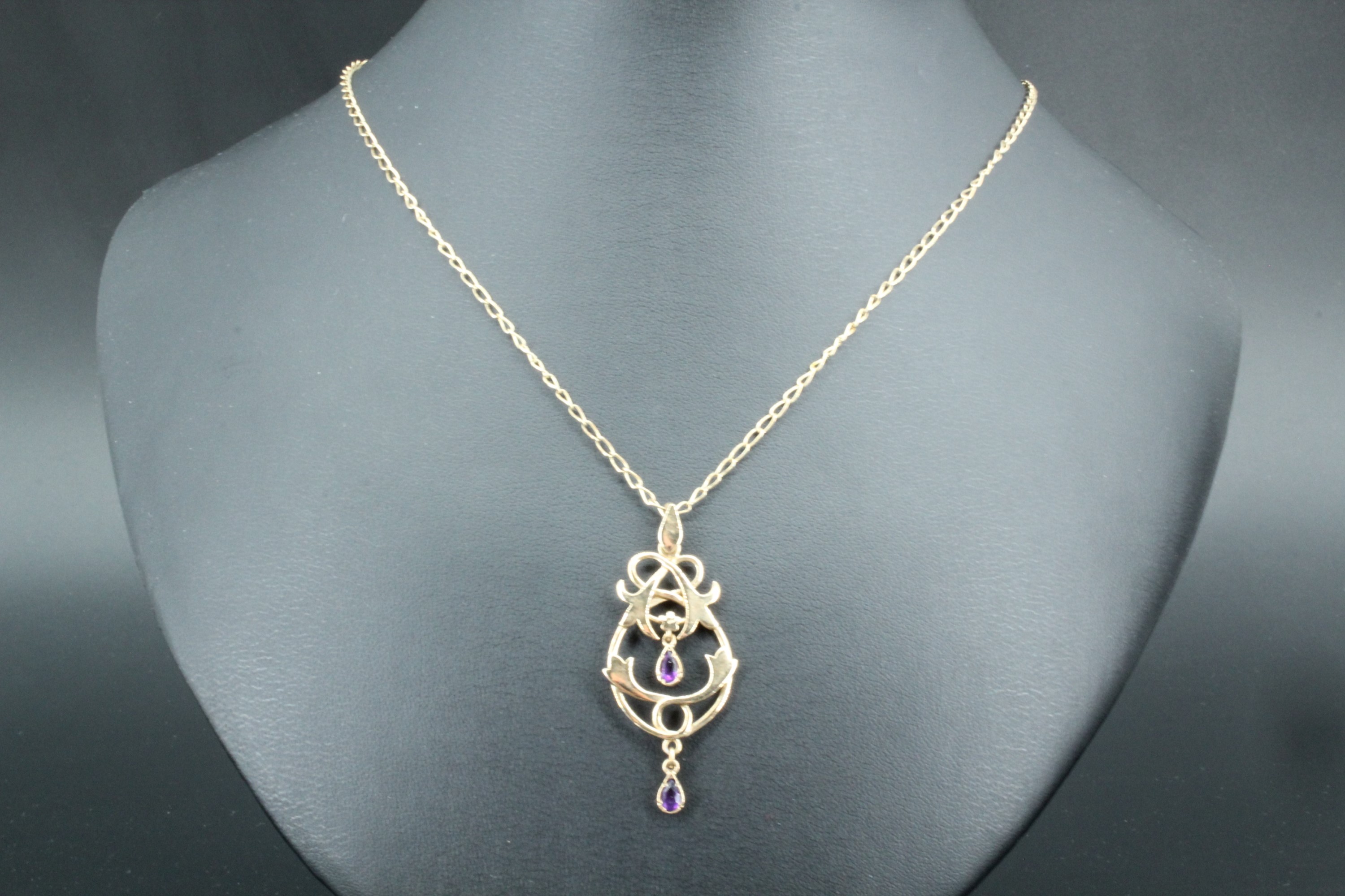 An amethyst set gold pendant, having floral scrolls suspending two pear shaped amethysts, 9 ct gold, - Image 2 of 2