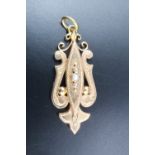 A Victorian yellow metal and seed pearl pendant, comprising a central vertical navette plaque set