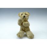A vintage golden plush Teddy bear, wood wool filled and having glass eyes, 28 cm