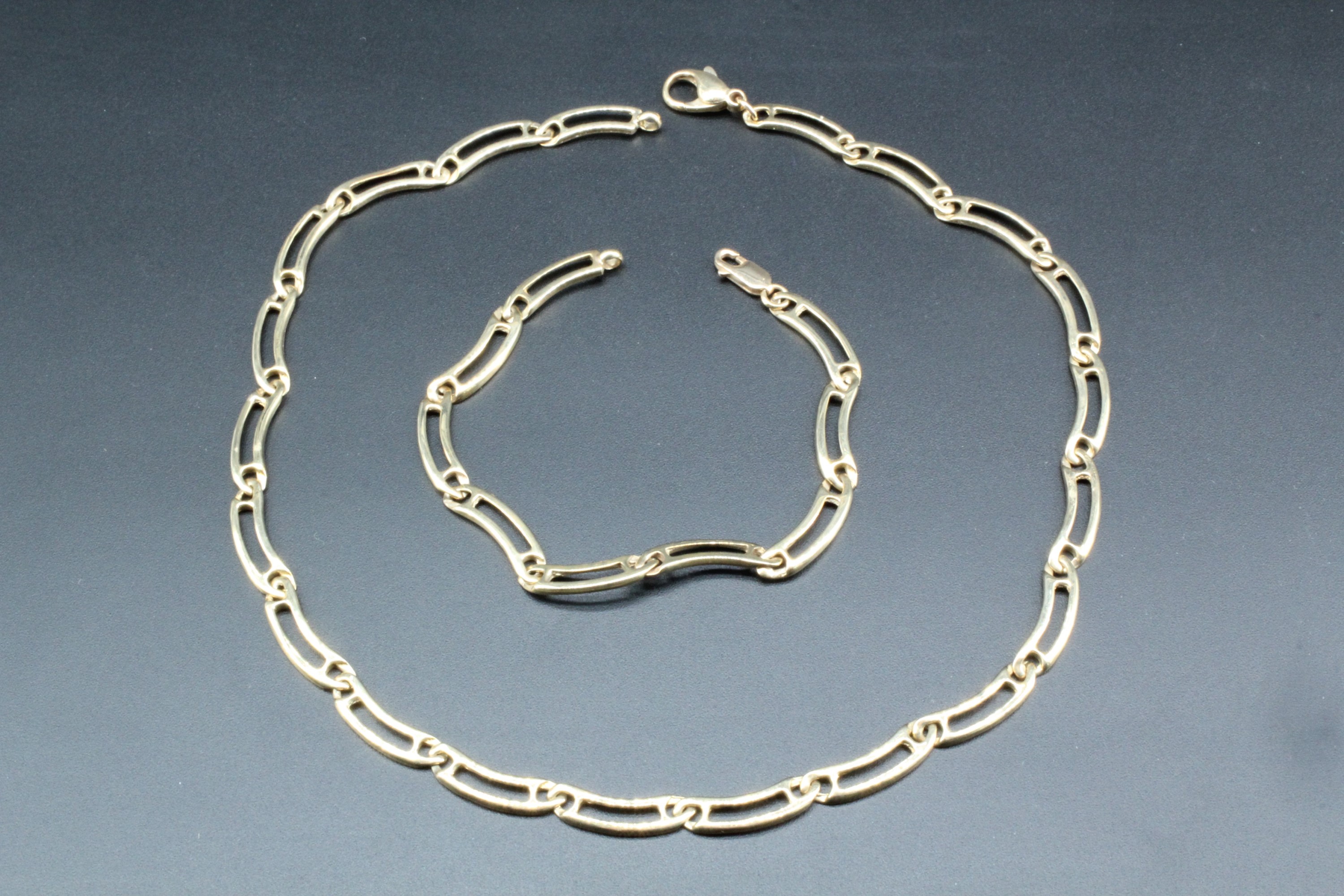 A contemporary 9 ct gold collar necklace of elongated contoured links, 40 cm, together with a