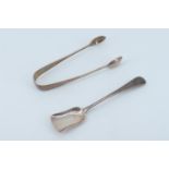 A pair of George V silver sugar tongs and a sugar spoon, both engraved with a crest depicting a bird