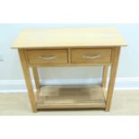 A contemporary oak side table, having a pair of drawers and glass-topped base shelf, 35 cm x 84 cm x