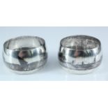 Two Middle Eastern white metal and niello napkin rings, each decorated in depiction of a river,