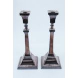 A pair George VI neoclassical silver candlesticks, of unadorned square form with a beaded edge base,