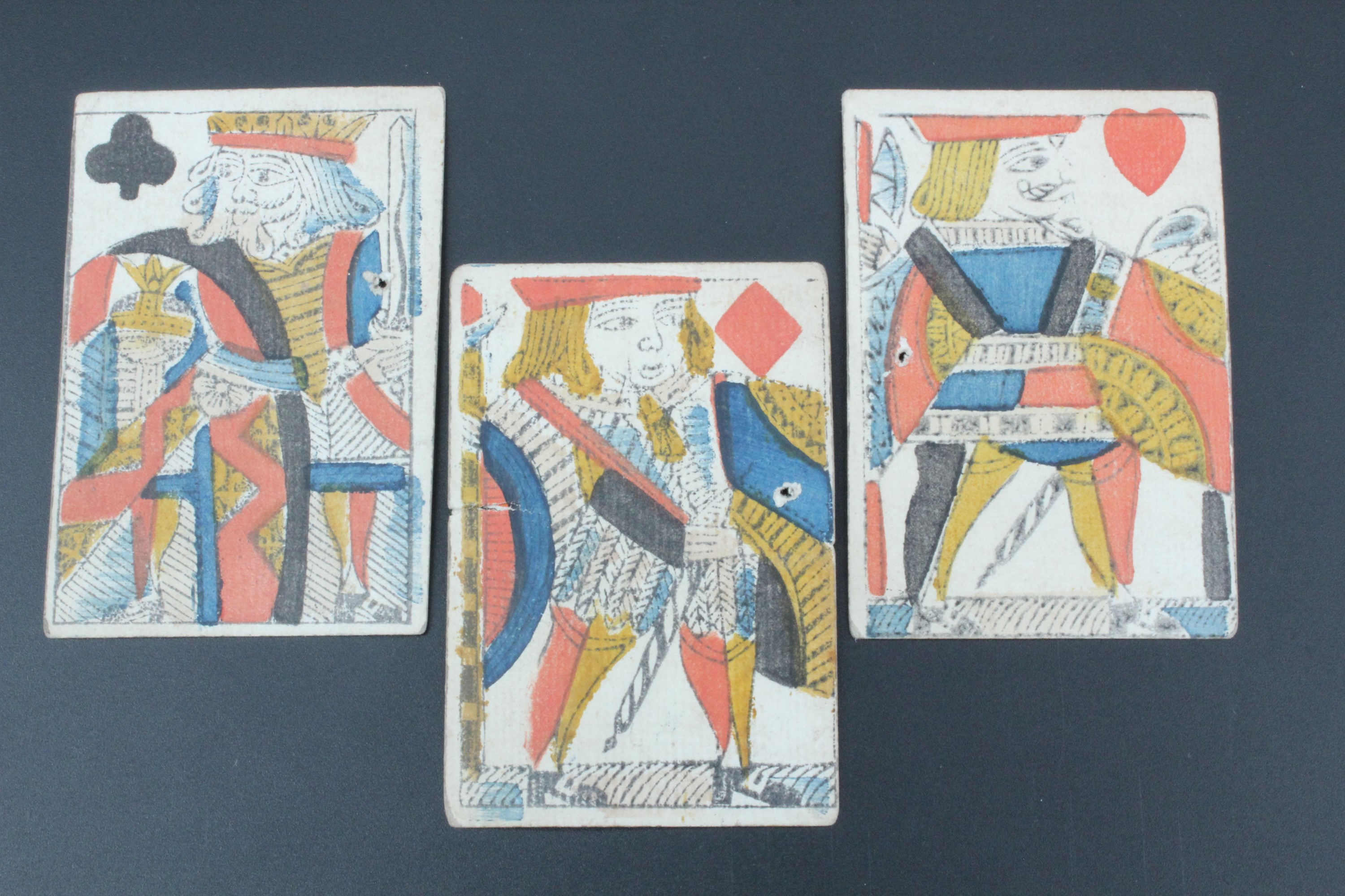 Three 18th Century printed and watercolour tinted playing card, having been used as labels and