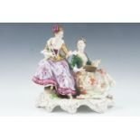 An East German porcelain figure group by Rudolph Kammer, two ladies discussing music, decorated with