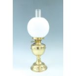 A brass oil lamp having a milk glass globe / shade, 52 cm to top of funnel