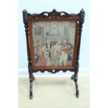A Victorian carved mahogany fire screen, bearing a gros and petit point needlework depicting a royal