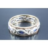 A sapphire and two tone 9 carat gold eternity ring, having seven marquis sapphires between