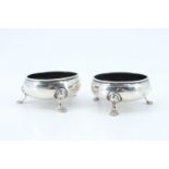 A pair of George III silver salt cellars, of oblate form on three pad feet bearing an engraved "