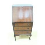 A George V string-inlaid and cross-banded mahogany fall front bureau, of slender diminutive stature,