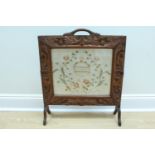 A carved oak and embroidery fire screen, second quarter 20th Century, 59 cm x 70 cm