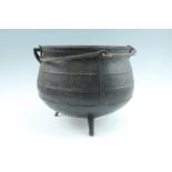 An antique cast iron cauldron with detachable articulated swing handle, (in uncommonly fine