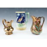 A Victorian majolica earthenware jug together with two copper luster jugs, former 21 cm