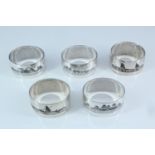 Five Middle Eastern white metal and niello napkin rings, each decorated in depiction of a river