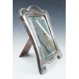 George V silver dressing table mirror / photograph frame, having sinuous shape with a ribbon and