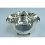 An early 20th Century silver quatrefoil bowl, having four lobes and a beeded edge, raised on four