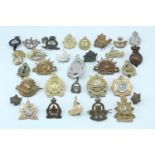 A quantity of Commonwealth / Dominions cap badges etc