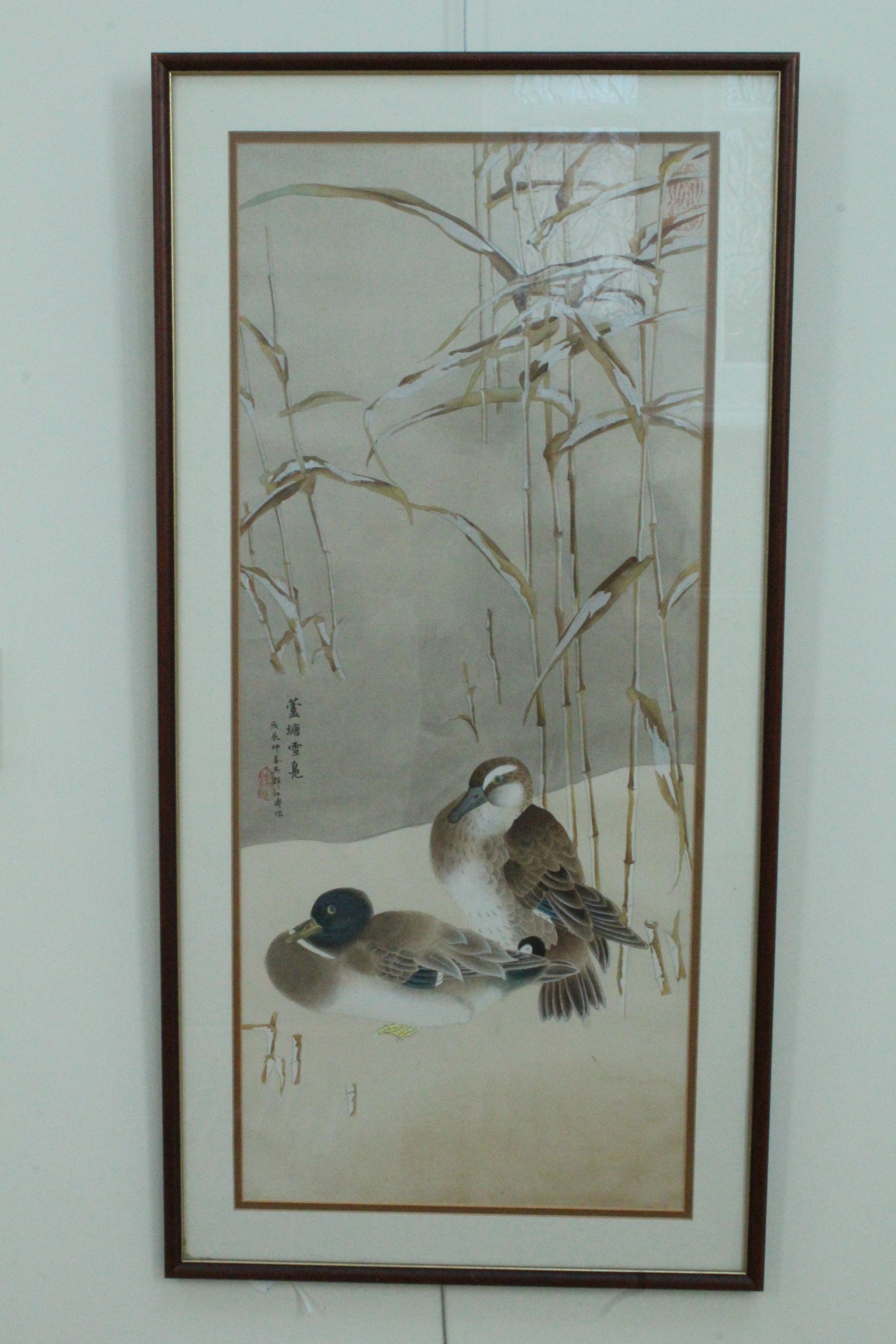 A Chinese watercolour painting on fabric of a pair of ducks resting under bamboo, in double card