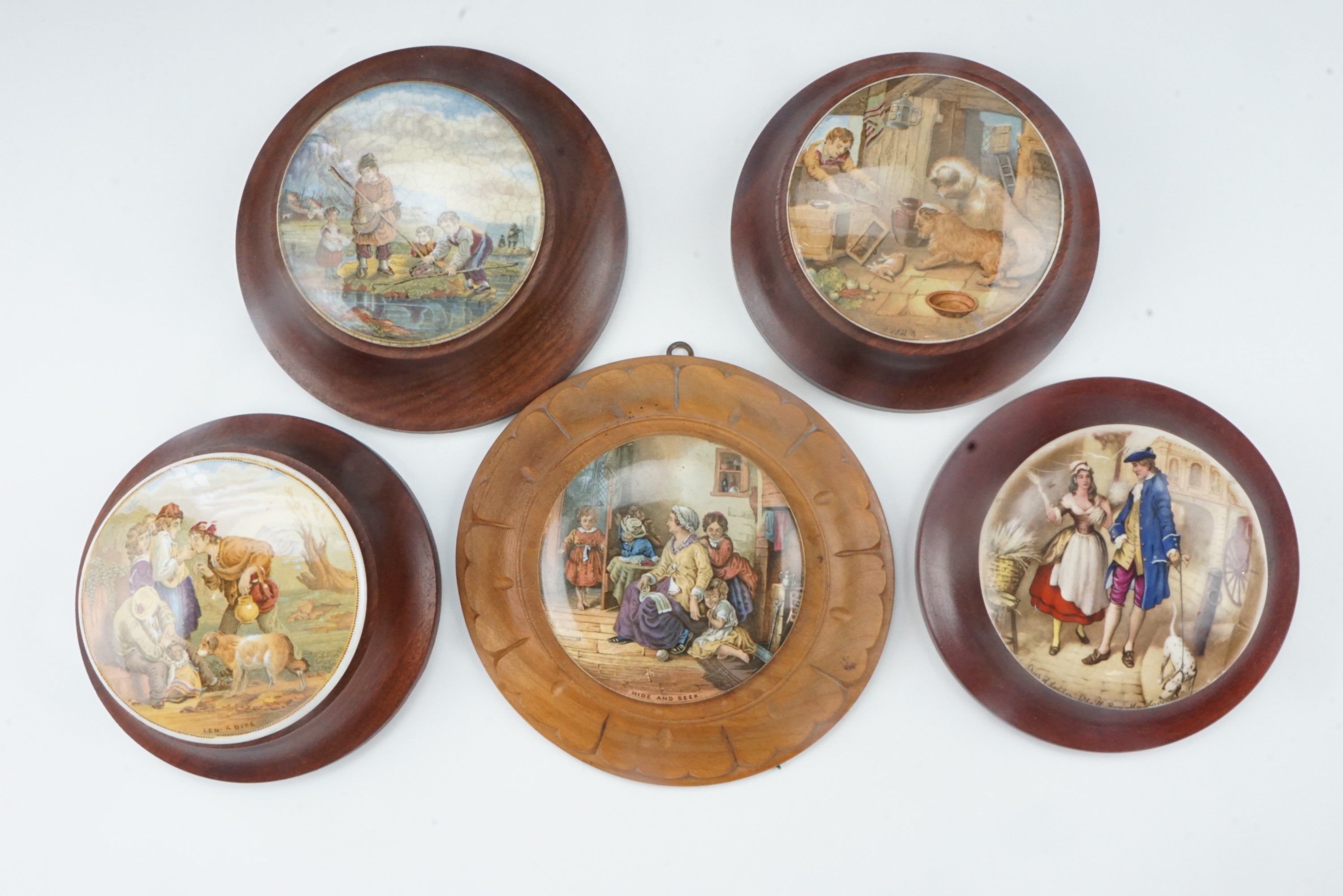 Four Victorian Pratt ware pot lids in frames, comprising "Len a Bite", "Hide and Seek", "The