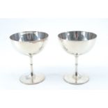 A pair of late Victorian silver wine cups, on slender stems, having a knop and beaded decoration,