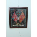 A late 19th Century Border Regiment wool-work, framed under glass with pagri badge or helmet plate