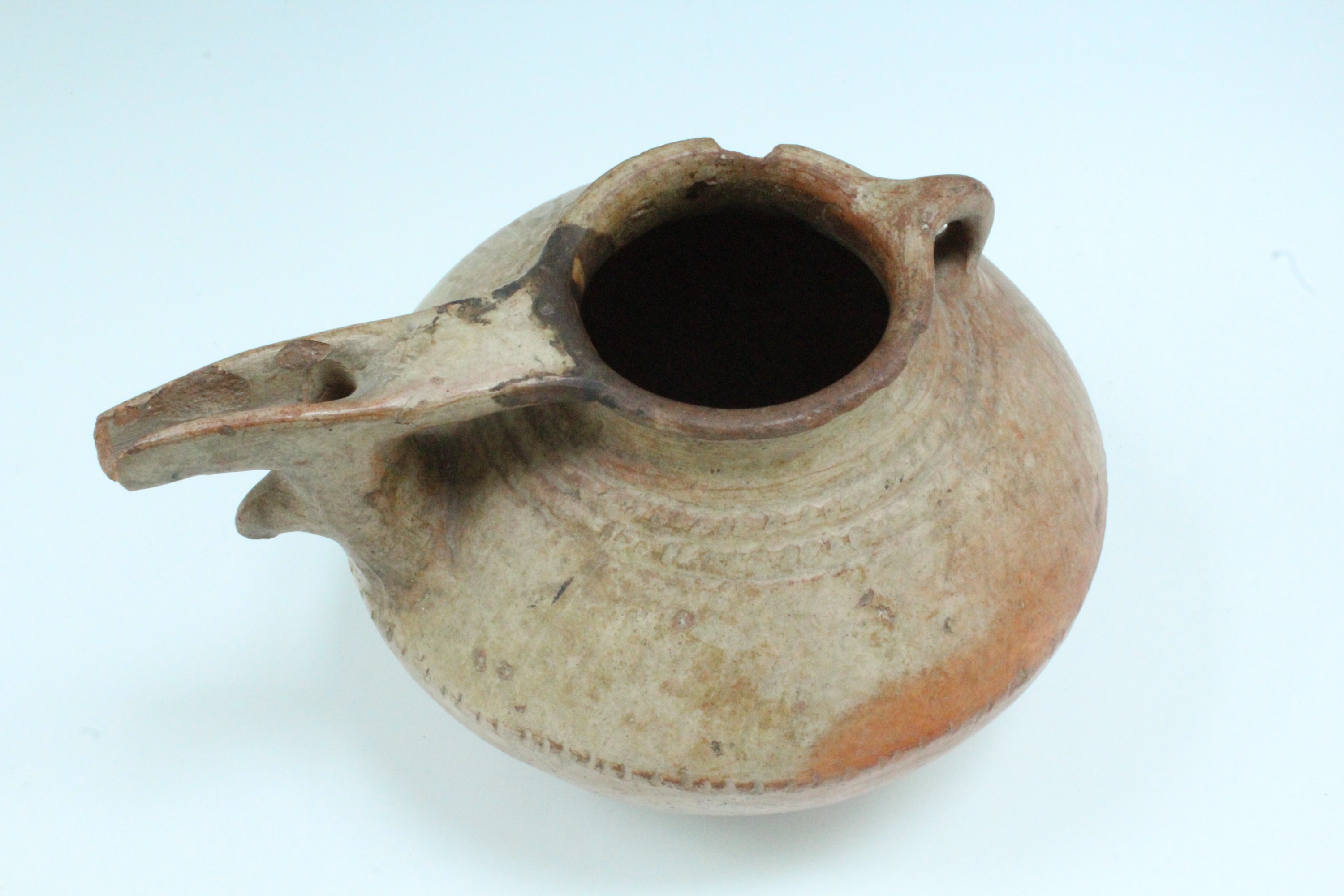 An ancient Luristan earthenware spouted vessel, of lenticular form with bridged spout and opposed - Image 2 of 4
