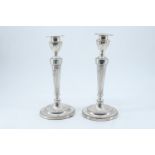 A pair of Victorian silver candlesticks, having urn shaped nozzles with detachable bobeches, and