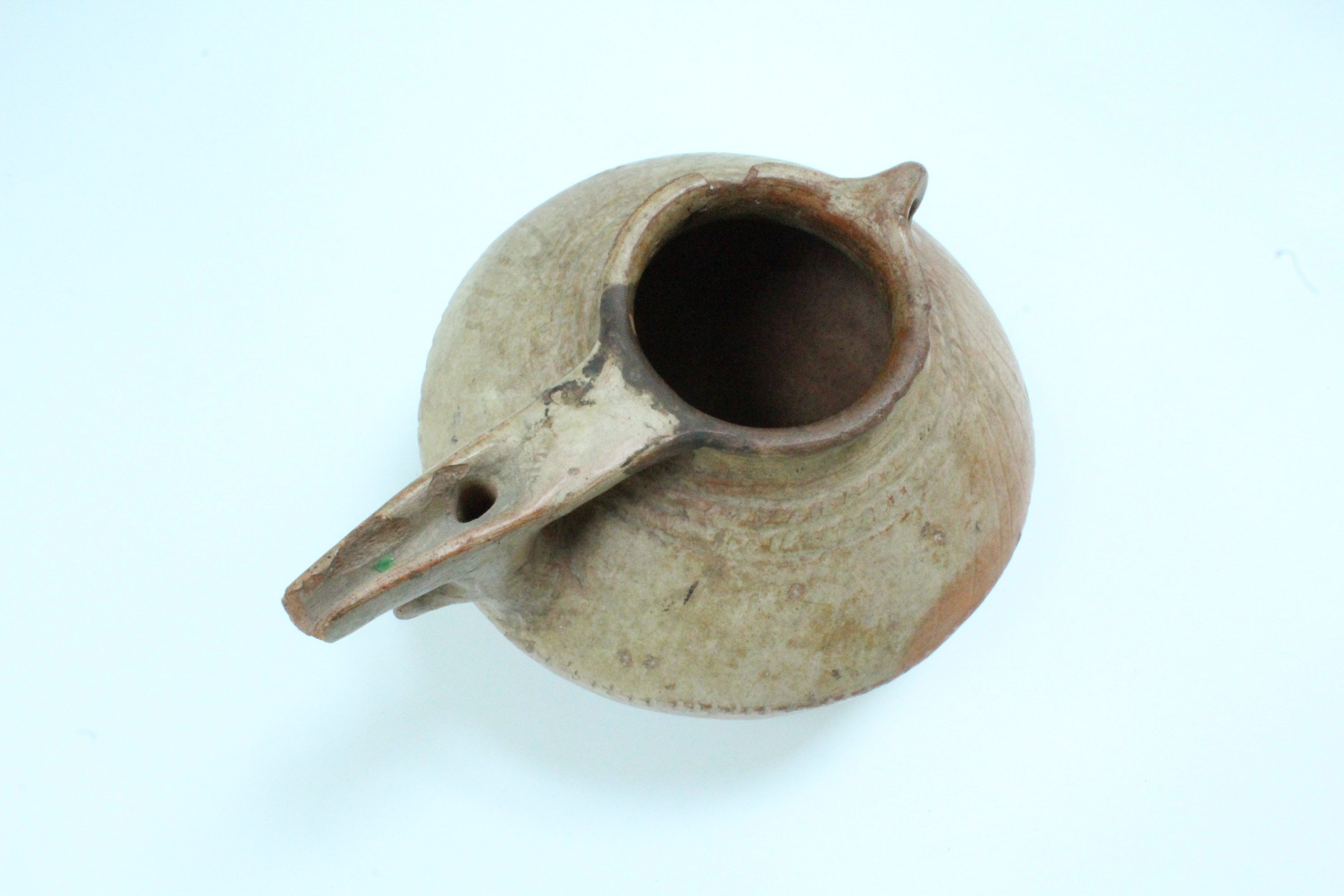An ancient Luristan earthenware spouted vessel, of lenticular form with bridged spout and opposed - Image 4 of 4
