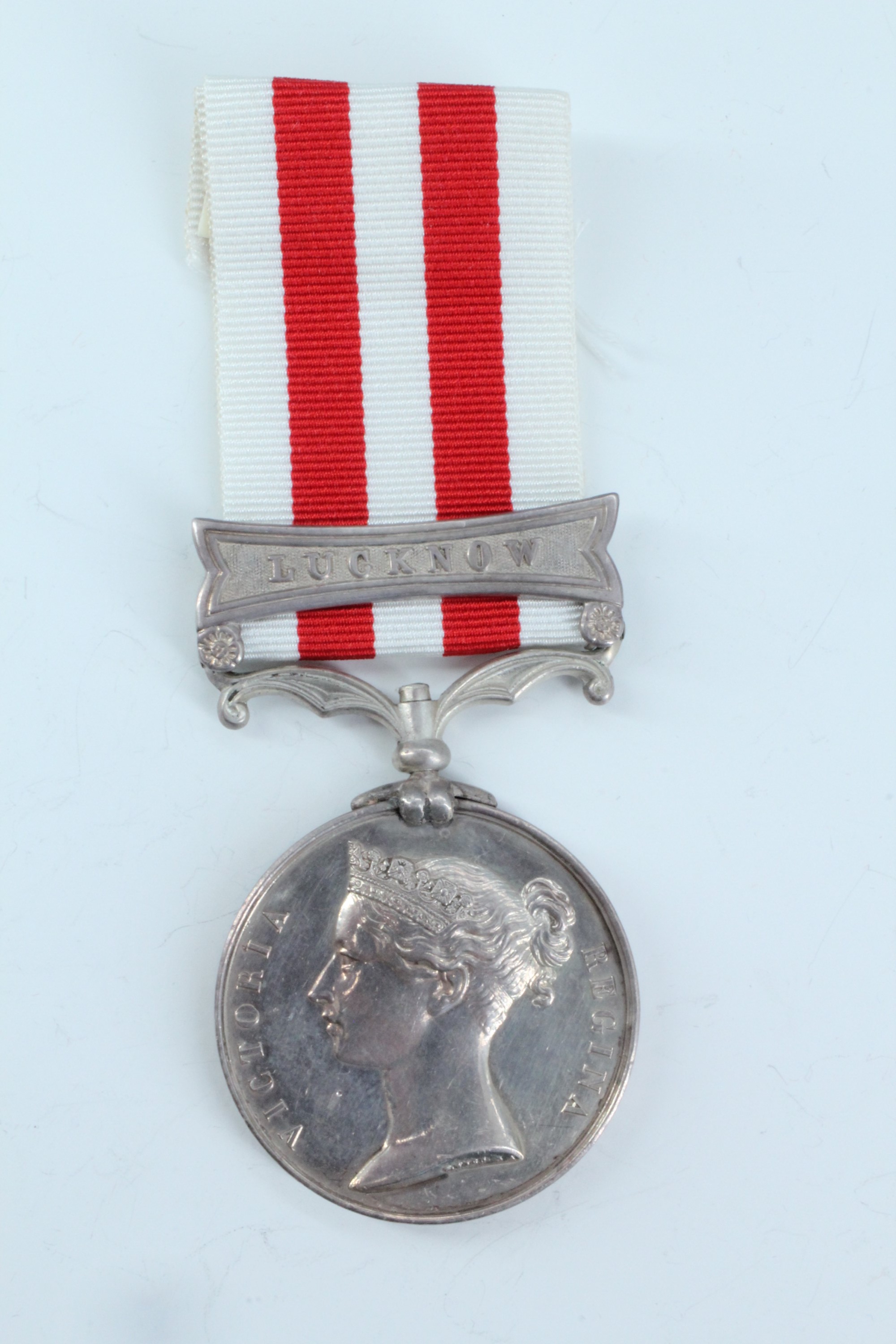 An Indian Mutiny medal with Lucknow clasp impressed to Ens H P Evans, Attd to H M 34th Regt