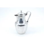 An early 20th Century silver hot water jug, of shouldered baluster form with a ribbon handle,