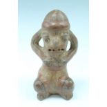 A South American ceramic figure, in the form of a squatting stylized female, painted terracotta,