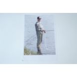 A signed image of Jack Charlton fly fishing at the edge of a river, colour print on A4 paper, 23 x