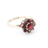 A garnet flowerhead cluster dress ring, the stones set in a 9 ct gold shank with chenier