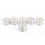 A set of six Elizabeth II silver napkin rings, having banded decoration and moulded edges, un-