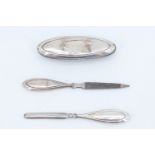 An early 20th Century three-piece silver manicure set comprising a nail buff, cuticle pusher and