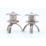 A pair of late 20th Century white metal salt and pepper condiments, formed as hexagonal pagodas on