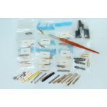 A quantity of fountain and dip pen replacement nibs, pocket clips and part bodies, together with a