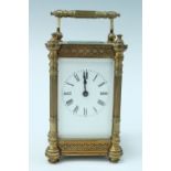 An early 20th Century brass carriage clock, key wound movement with a white enamel dial, having four