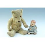 A plush Teddy bear, having glass eyes and articulated joints, together with a composition doll,