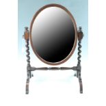 An early 20th Century mahogany oval toilet mirror, having barley twist supports and turned
