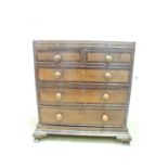 An early 19th Century mahogany cross-banded oak bachelor's chest, having a brushing slide and