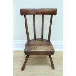 An early 19th Century child's comb-back milking style stool, 58 cm