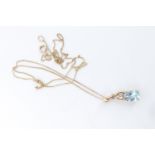 A contemporary blue topaz, white stone and 9 ct gold pendant, on a fine link 9 ct neck chain, drop