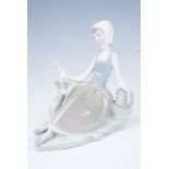 A Lladro figurine of a seated young girl with a bird, 16.5 cm