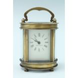 A diminutive mid 20th century oval bodied brass carriage clock, key wind and set, the case having