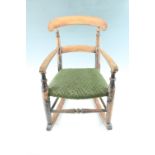 A Victorian child's fruitwood and beech rocking chair, having an upholstered seat and retaining some