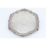 A late Victorian lobed circular silver salver, having a gadrooned and shell decorated edge, bright