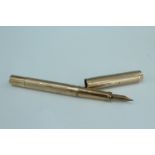 An Onoto 9 ct gold vacuum fill fountain pen, having an engine turned body with a vacant cartouche,