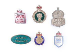 A Women's Land Army cap badge together with a silver ARP badge, a WRVS Trainer enamelled lapel and